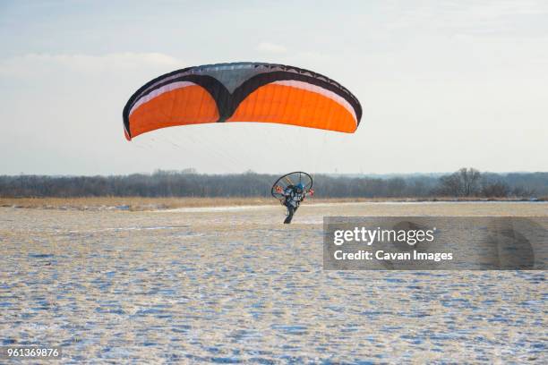 young man motor paragliding against sky - motor paraglider stock pictures, royalty-free photos & images