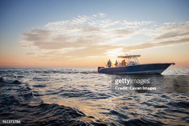 friends enjoying on boat at sea against sky during sunset - nautical stock pictures, royalty-free photos & images