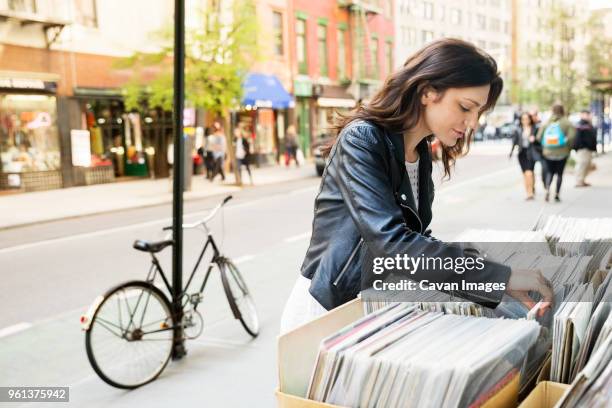young woman selecting magazine at market stall - abundance stock pictures, royalty-free photos & images