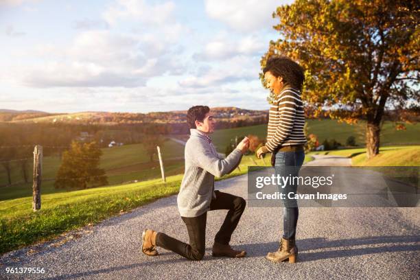 man proposing surprised girlfriend on footpath - black women engagement rings imagens e fotografias de stock