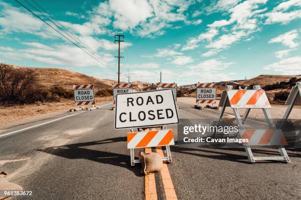 warning signs on country road against cloudy sky - detour stock pictures, royalty-free photos & images