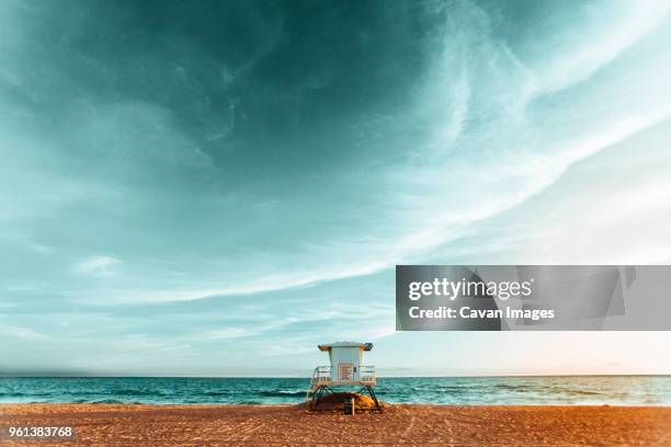 lifeguard hut on beach against cloudy sky - lifeguard tower bildbanksfoton och bilder