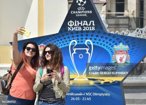 Girls make selfie in front of the official logo set on the Independence Square in the Ukrainian capital of Kiev on May 22 ahead of 2018 UEFA...
