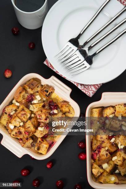 overhead view of cranberry bread pudding served with plates and forks on table - bread dessert stock pictures, royalty-free photos & images