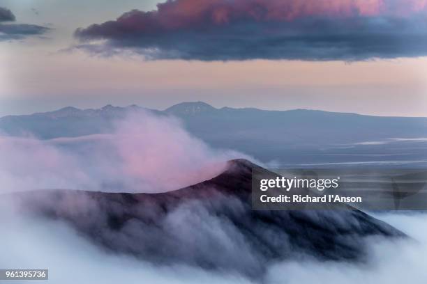 cloud rises on a cinder cone on tolbachik volcano at sunrise - cinder cone volcano stock-fotos und bilder
