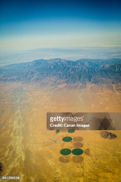aerial view of center pivot irrigation at desert against blue sky - center pivot irrigation stock pictures, royalty-free photos & images