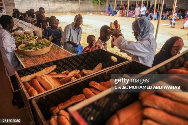 Somali internally displaced people wait in a line for food distribution in Mogadishu on May 22, 2018. - About 800 internally displaced people from 8...