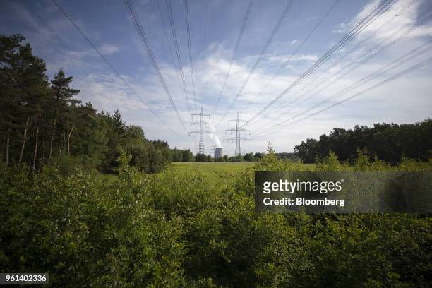 Power lines hang from a transmission pylons as a cooling tower emits vapor at the coal powered power plant operated by RWE AG in Lingen, Germany, on...