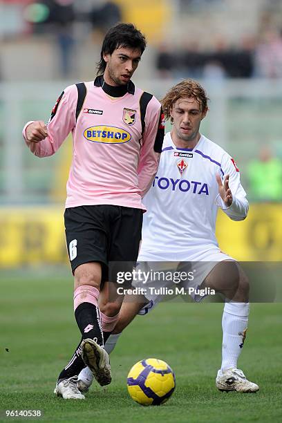 Javier Pastore of Palermo holds off the challenge from Marco Donadel of Fiorentina during the Serie A match between Palermo and Fiorentina at Stadio...