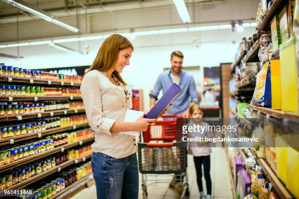 family shopping - woman picking up toys stock pictures, royalty-free photos & images