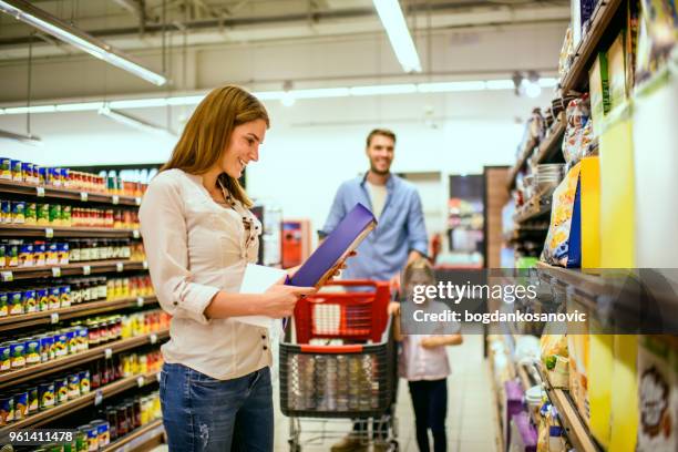 family shopping - woman picking up toys stock pictures, royalty-free photos & images