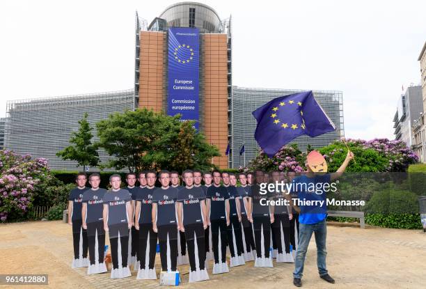 An Avaaz activist attends an anti-Facebook demonstration with cardboard cutouts of Facebook chief Mark Zuckerberg, on which is written "Fix...