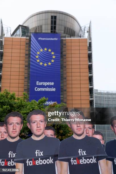 An Avaaz activist attends an anti-Facebook demonstration with cardboard cutouts of Facebook chief Mark Zuckerberg, on which is written "Fix...