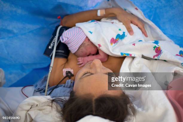 father kissing newborn son sleeping in crib at hospital - genderblend2015 stock pictures, royalty-free photos & images