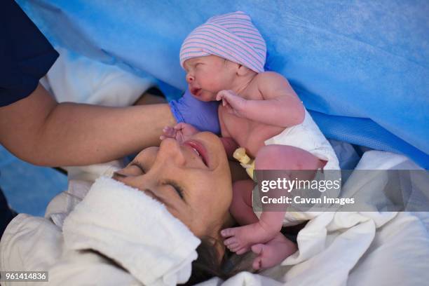 high angle midsection of father with newborn son sitting on chair at hospital - birthing chair stock pictures, royalty-free photos & images