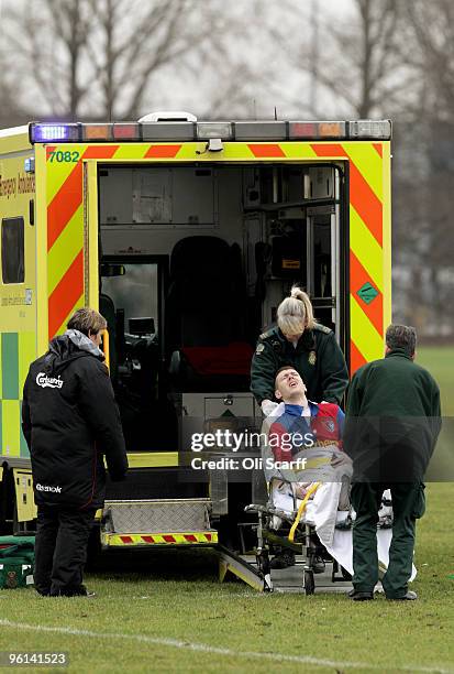 Sunday League footballer grips his leg in pain as he is lifted into the back of an ambulance by paramedics on the Hackney Marshes pitches on January...