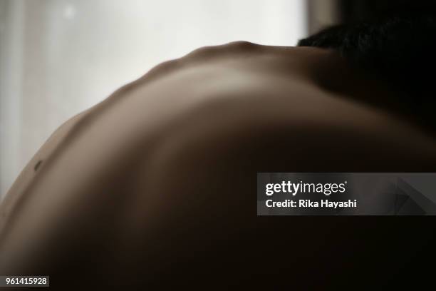 a round-shouldered man in the room. - atrésie photos et images de collection