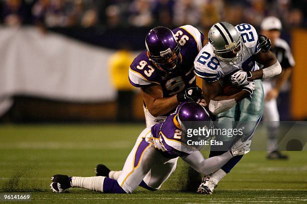 Running back Felix Jones of the Dallas Cowboys is tackled by Kevin Williams and Madieu Williams of the Minnesota Vikings during the NFC Divisional...