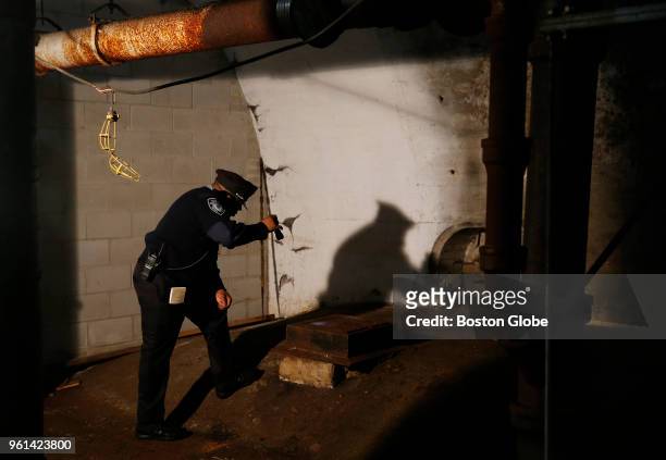 Municipal officer shines his light inside an abandoned subway tunnel under City Hall Plaza in Boston on May 21, 2018. Opened in 1898, the tunnel was...