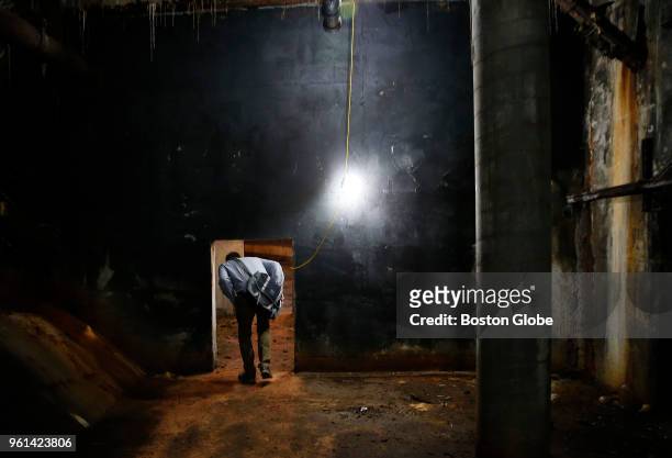 City Archaeologist Joseph Bagley ducks down as he passes through a door in an abandoned subway tunnel under City Hall Plaza in Boston on May 21,...