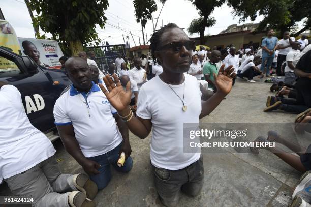 People kneel to pray for victims of violent attacks across the country at Ikeja St Leo Catholic Church, Ikeja in Lagos, on May 22, 2018. - Catholic...