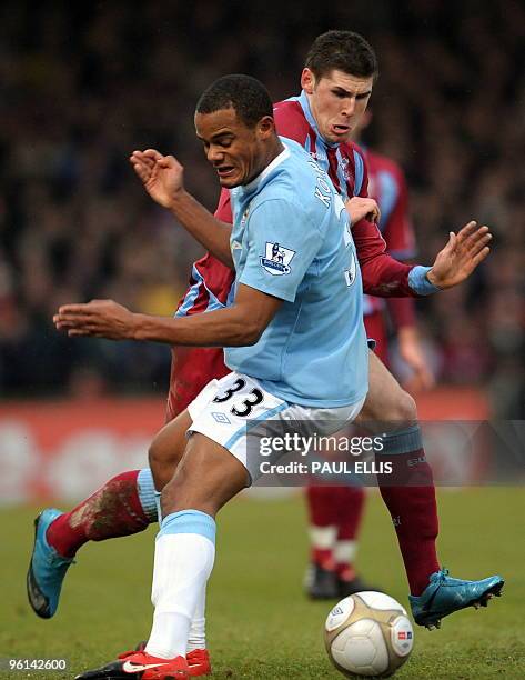 Scunthorpe United's Gary Hooper is tackled by Manchester City's Belgian midfielder Vincent Kompany during their English FA Cup football match at...