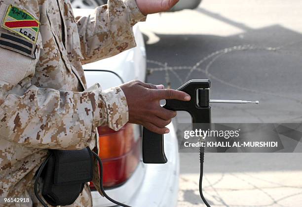 File picture dated November 9, 2009 shows an Iraqi police man holding a ADE651 bomb detector device as he walks along side a stopped vehicle at a...