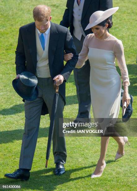 Britain's Prince Harry, Duke of Sussex and his new wife Britain's Meghan, Duchess of Sussex, attend the Prince of Wales's 70th Birthday Garden Party...