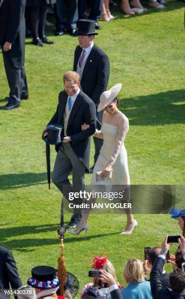 Britain's Prince Harry, Duke of Sussex and his new wife Britain's Meghan, Duchess of Sussex, attend the Prince of Wales's 70th Birthday Garden Party...