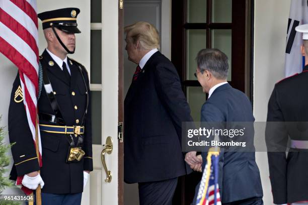 President Donald Trump, center, holds the hand of Moon Jae-in, South Korea's president, while walking into the West Wing of the White House in...