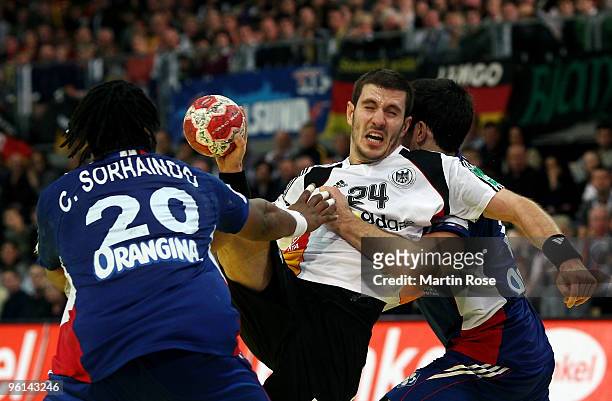 Michael Haass of Germany in action with Nikola Karabatic and Cedric Sorhaindo of France during the Men's Handball European main round Group II match...