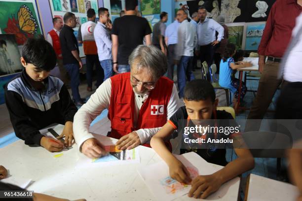 President of International Federation of Red Cross and Red Crescent Societies Francesco Rocca draws with children during his visit at a child...