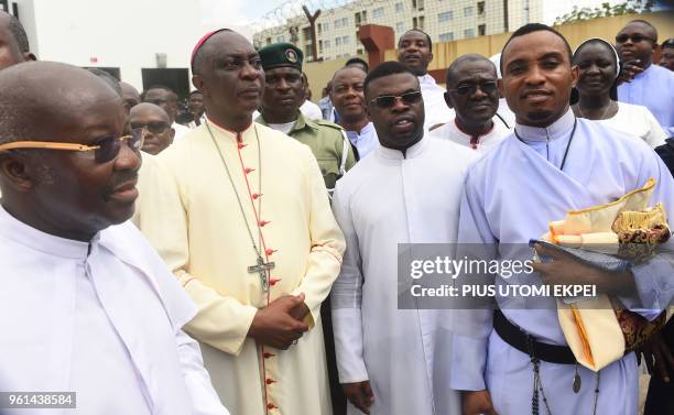 Catholic Archbishop of Lagos Alfred Adewale Martins and other senior members of the diocese look on as policemen install a barrier to stop protesters...