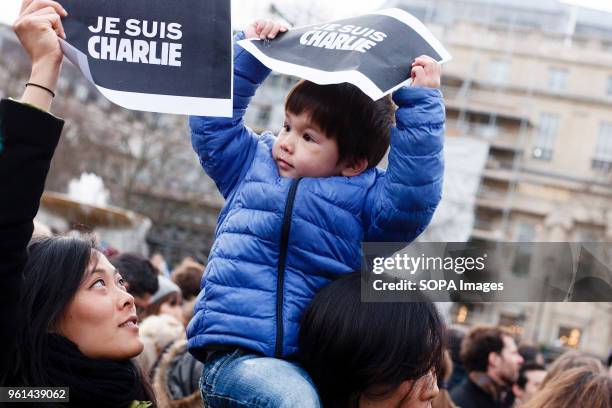 Woman and young boy hold up signs reading "Je suis Charlie" at a solidarity and remembrance rally in Trafalgar Square called in response to a...