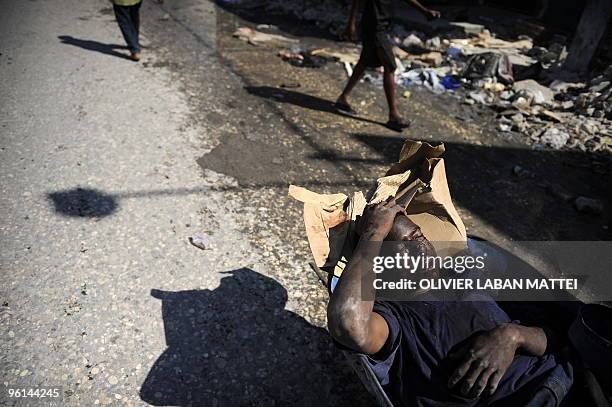 Young Haitian looter is carted to the hospital bywheel barrow after he was alegedly shot by police on January 24 2010, in the streets of...