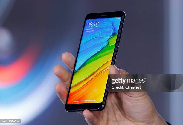 Senior Vice President, Wang Xian of the Chinese electronics and computer company Xiaomi specializing in mobile telephony Xiaomi shows a Redmi Note 5...