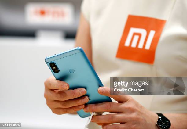 An employee holds a Redmi Note 5 smartphone from the Chinese electronics and computer company Xiaomi specializing in mobile telephony at the Xiaomi...