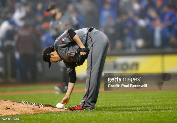 Pitcher Yoshihisa Hirano of the Arizona Diamondbacks picks up the rosin bag near the pitchers mound before pitching in relief in the 7th inning in an...