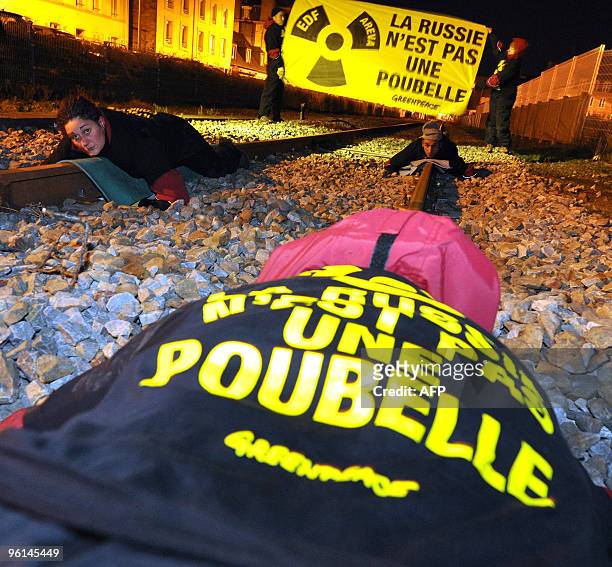 Four Greenpeace activists chained themselves at a railway, on January 24, 2010 near the ferry terminal at Cherbourg, western France, to prevent the...