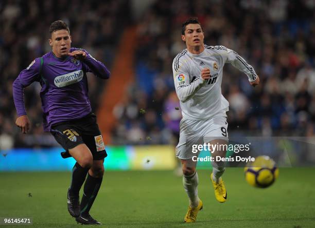 Cristiano Ronaldo of Real Madrid outpaces Ivan Gonzalez of Malaga during the La Liga match between Real Madrid and Malaga at the Santiago Bernabeu...