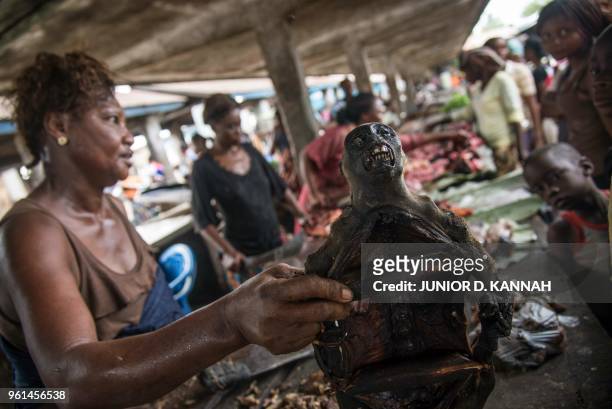 Vendor holds a monkeys head on display with other cuts of bush meat at a market in Mbandaka on May 22 in the Democratic Republic of Congo. - Health...