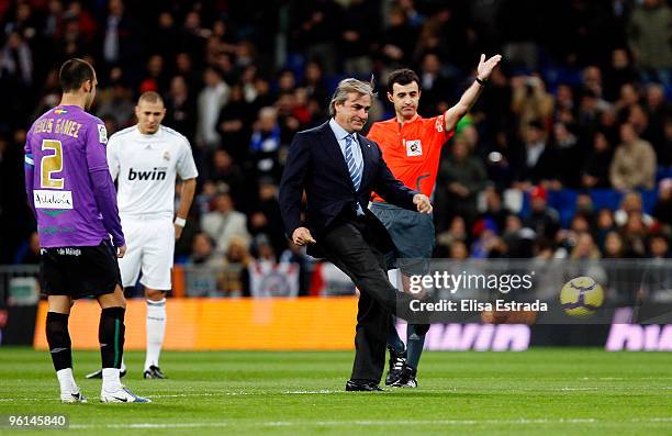 Spanish rally driver Carlos Sainz kicks the ball before the la Liga match between Real Madrid and Malaga at Estadio Santiago Bernabeu on January 24,...