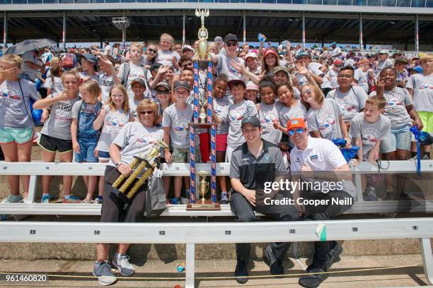 Gabby Chaves and Scott Dixon present Rayzor Elementary School with their co-school championship trophy during the first day of Speeding To Read at...