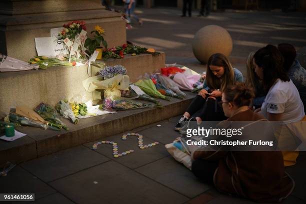 Teenage girls sing Ariana Grande songs near floral tributes, in St Ann's Square on the first anniversary of the Manchester terrorist attack on May...