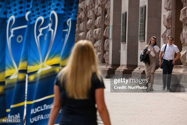 People walk past the flags with the UEFA Champions League final logo in central in Kyiv, Ukraine, May 22, 2018