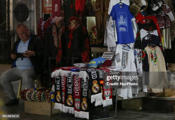 Foreigners walk past a man selling the scarfs with the symbols of teams participting UEFA Champions League final in central in Kyiv, Ukraine, May 22,...