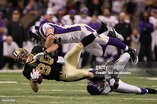 Jeremy Shockey of the New Orleans Saints gets tackled by Chad Greenway and Antoine Winfield of the Minnesota Vikings after catching a pass for a...
