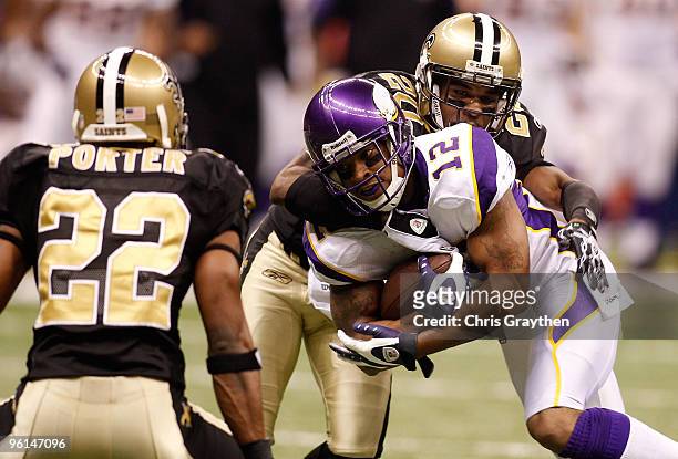 Percy Harvin of the Minnesota Vikings runs with the ball against Tracy Porter and Randall Gay of the New Orleans Saints during the NFC Championship...