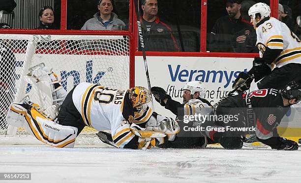 Mark Stuart of the Boston Bruins collides with goaltender Tim Thomas knocking the goal off its moorings during a NHL game against the Carolina...