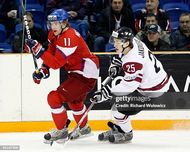 Andrej Nestrasil of Team Czech Republic and Martins Jakovlevs of Team Latvia chase the puck into the corner during the 2010 IIHF World Junior...